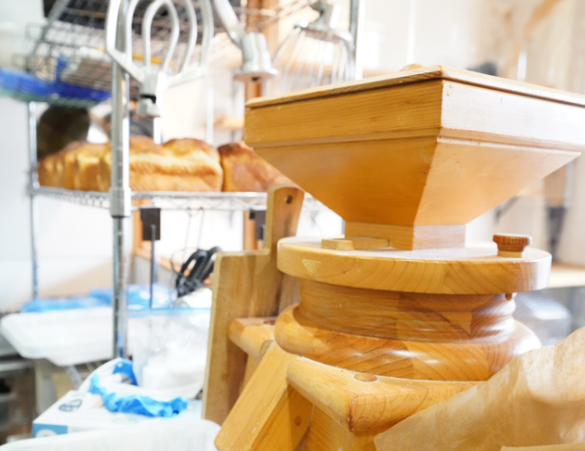 ナカツカサファームさんの小麦をお店にある木製の石臼で挽いて一部の商品に使用