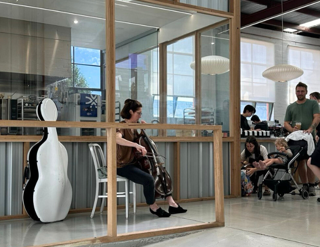 パン屋の店内でチェロをひく女性